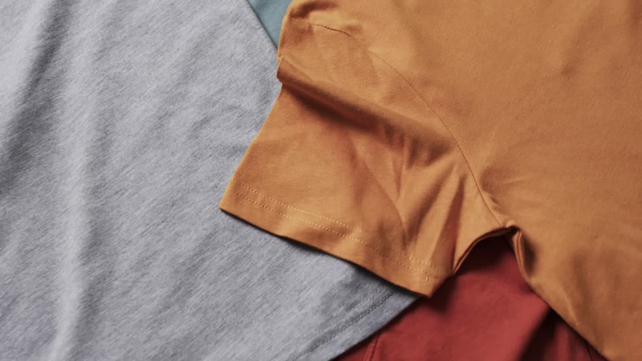 ⁇ 색 배경에 복사 공간이 있는 다채로운 티셔츠의 평평한 레이의 비디오