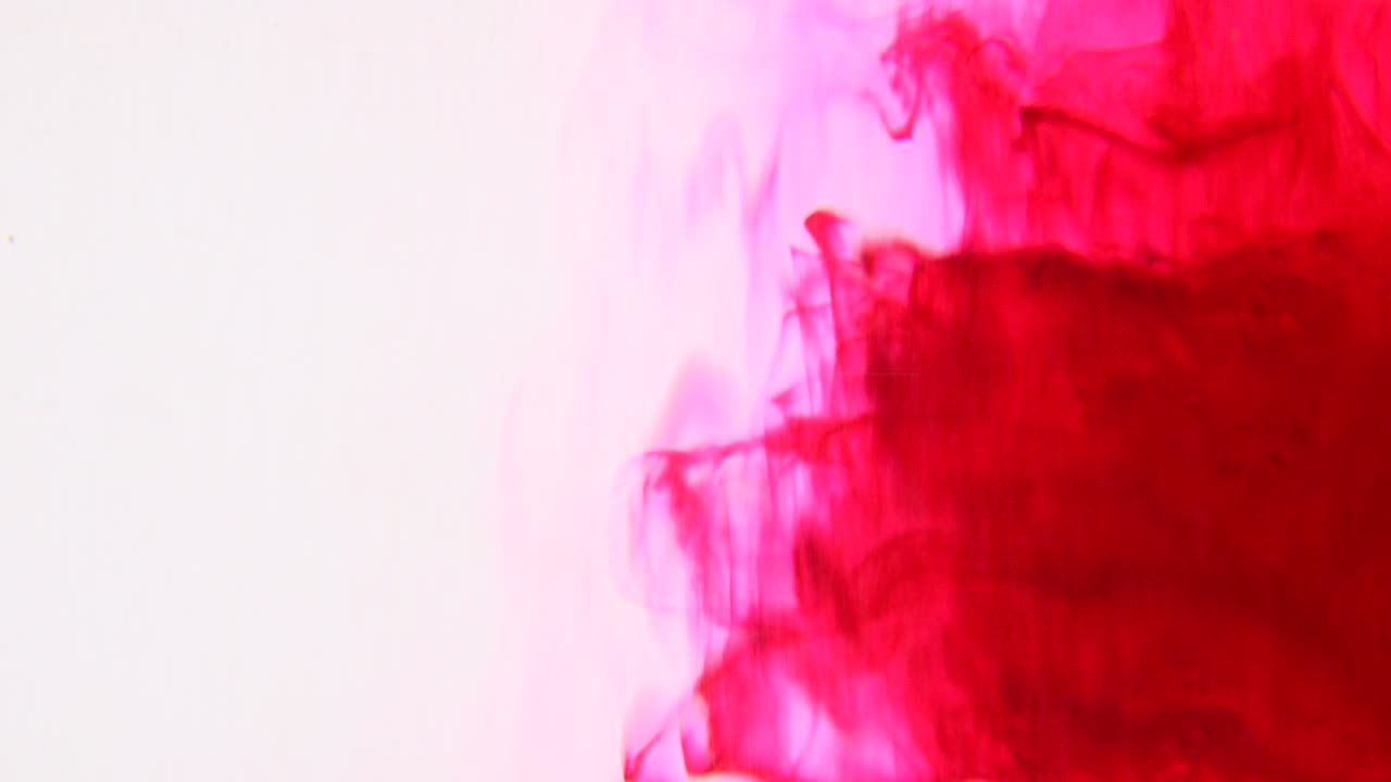 Experimental red ink spinning around in a vortex shape for a unique abstract background