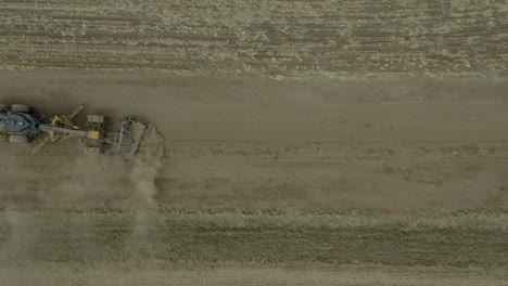 vista de arriba hacia abajo de la niveladora de carreteras suavizando la nueva carretera agrícola rural
