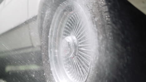 spraying a car wheel with water on a sunny summer day in canada