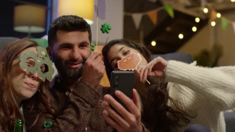 Group-Of-Friends-Dressing-Up-At-Home-Celebrating-At-St-Patrick's-Day-Party-Making-Video-Call-On-Mobile-Phone-2