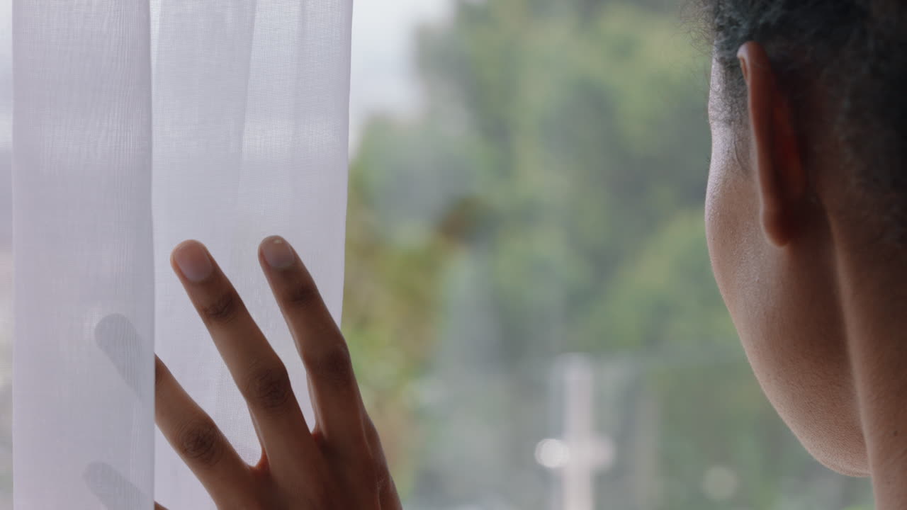 집에서 외로움을 느끼는 창문 밖을 바라보는 젊은 여성