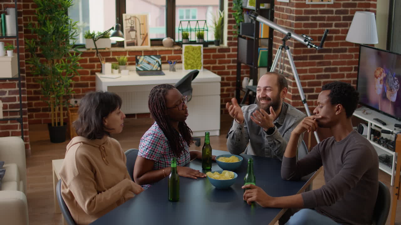 Multiethnic group of people enjoying food and drinks at home