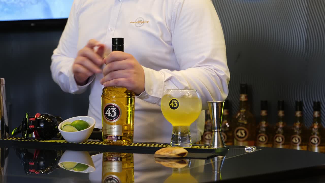 A man showcases the versatility of Spain’s iconic Licor 43 at a museum in Los Alcázares, captivating the audience with creative cocktail demonstrations.