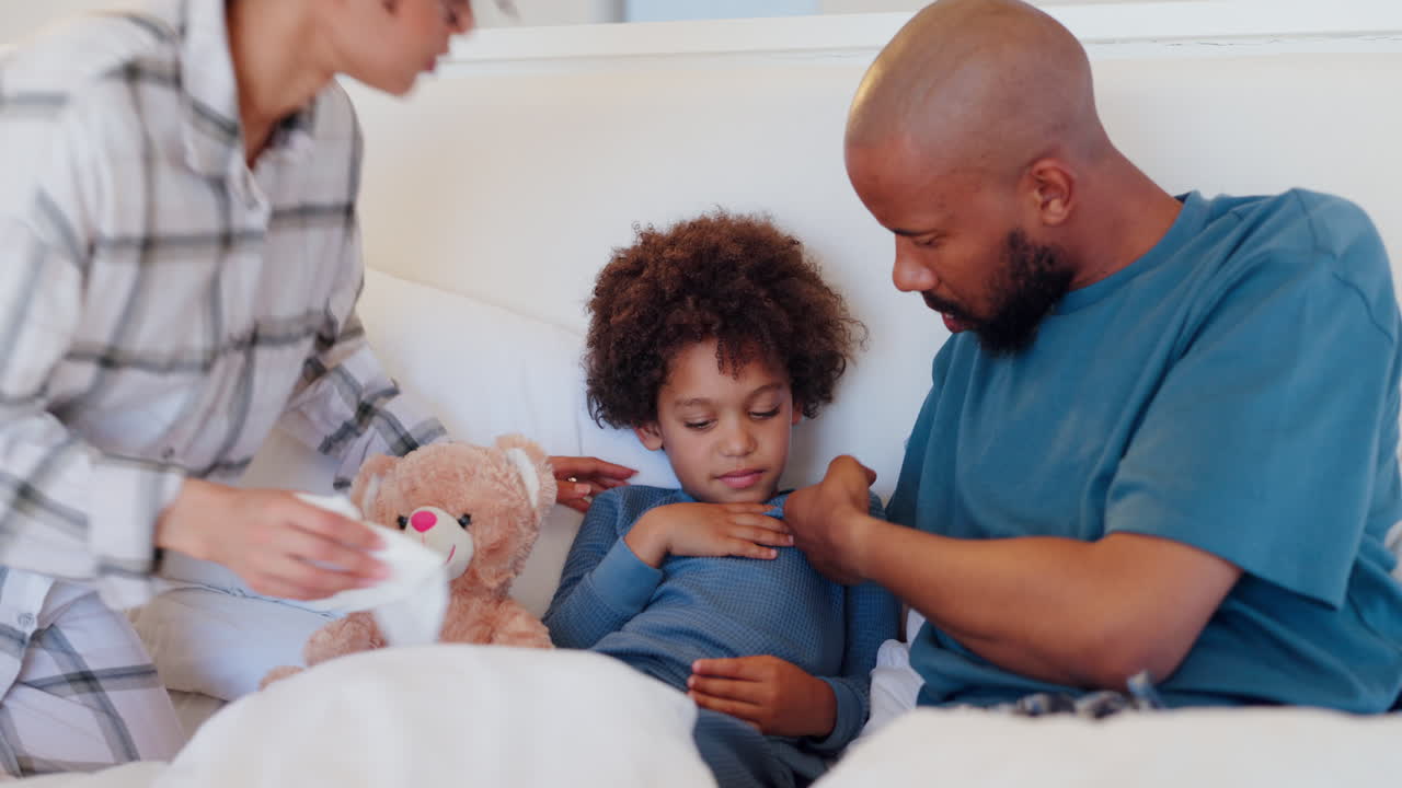 Malato, che si soffia il naso e un bambino a letto