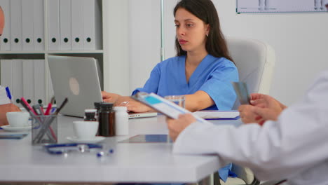 portrait of nurse typing on laptop looking at camera