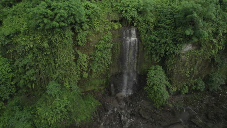 secret waterfall hidden in the jungle near ubud in bali, indonesia, drone pan right shot