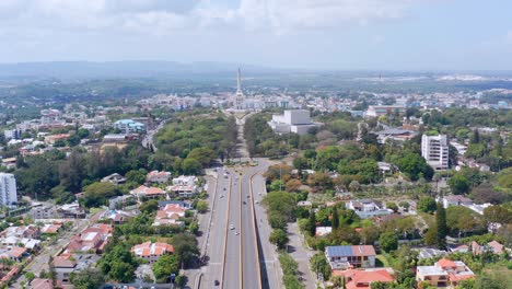 Aerial-backward-over-Santiago-de-los-Caballeros-with-patriotic-monument-in-background