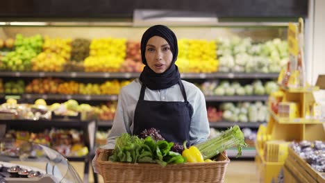 Muslimische-Frau-Im-Hijab-Geht-Mit-Einem-Korb-Mit-Frischem-Gemüse-Im-Supermarkt-Spazieren,-Zeitlupe