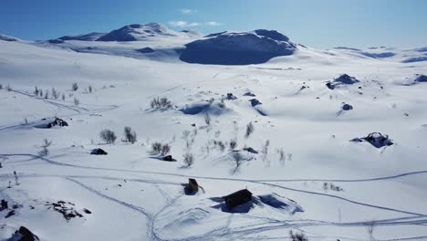 snowy landscape with the view of stf unna allakas mountain cabin in kiruna, sweden - aerial drone shot