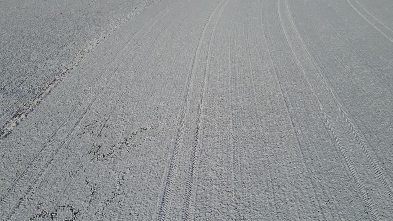 Snow covered agricultural field showing clean winter texture and crop line patterns across frozen farmland. Drone aerial winter landscape with pure snow surface and rural agricultural terrain Germany