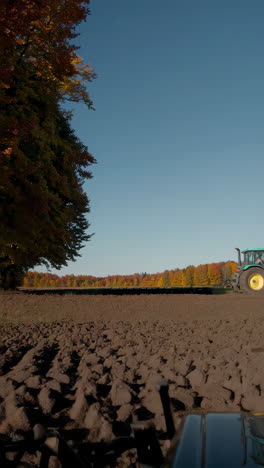 autumn farmland with tractor plowing