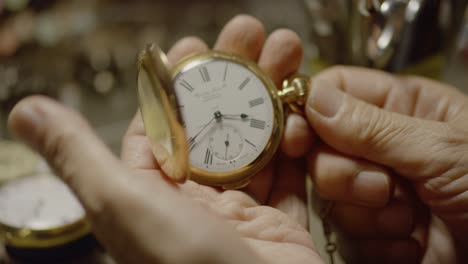 un hombre abre un reloj de bolsillo