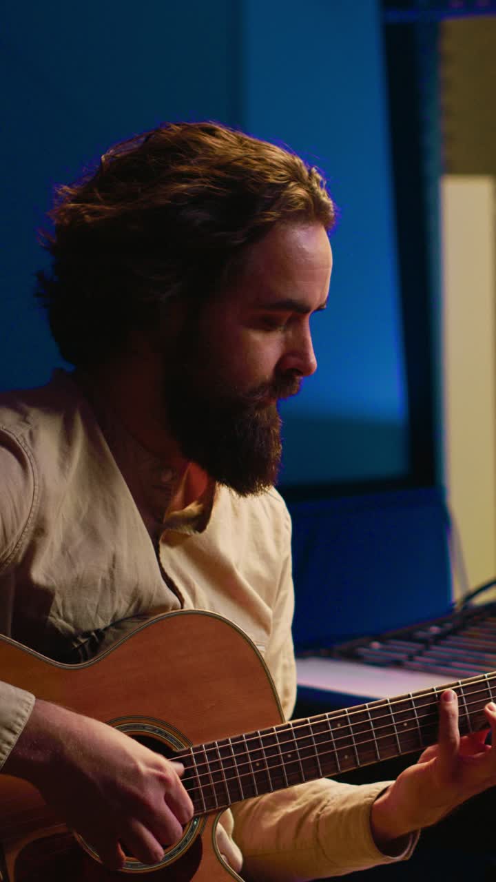 Hombre tocando la guitarra acústica en un estudio de música
