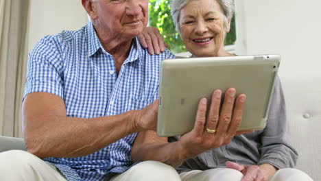 una pareja de ancianos usando una tableta.