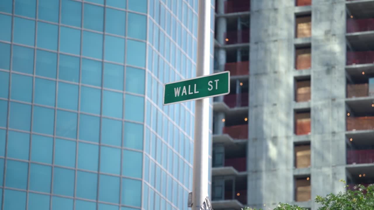 WALL STREET green sign in New York City. New Building and Building in Construction as Background. Non-conventional Wall Street sign.