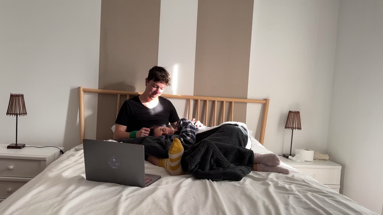 커플이 노트북과 함께 침대에서 휴식을 취하고 있습니다.