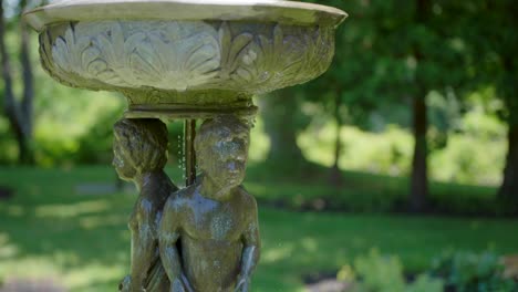 agua de fuente que fluye en elegantes esculturas en el parque en un día soleado