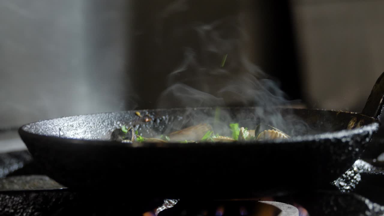 cooking mussels in pan with herbs