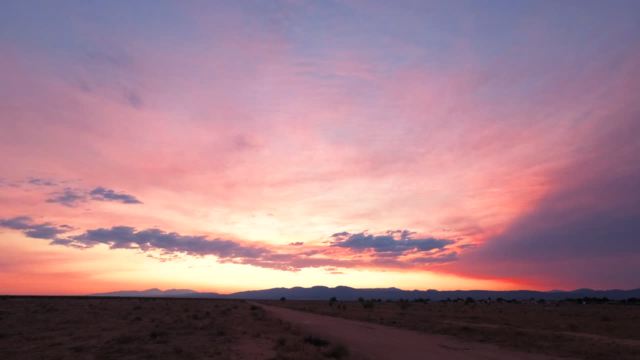 impresionante puesta de sol colorida contra el telón de fondo del desierto de mojave y la lejana cordillera - lapso de tiempo estático