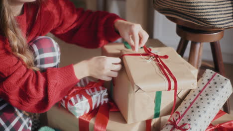 woman arranging wrapped christmas gifts at home