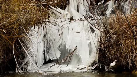 hielo salpicado formado por una cascada desde un canal lateral hasta el río bow en invierno