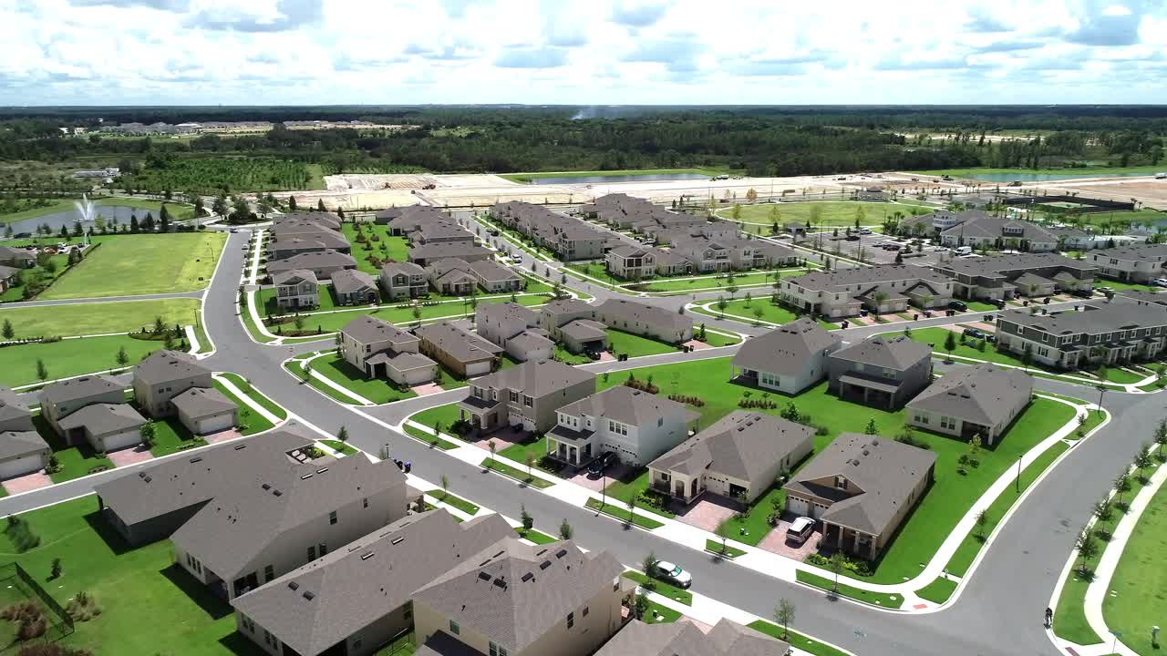 Aerial view of an upper middle class lakefront neighborhood subdivision with single family homes and townhouses, pool and clubhouse on a cloudy fall day in Winter Garden, Florida, USA