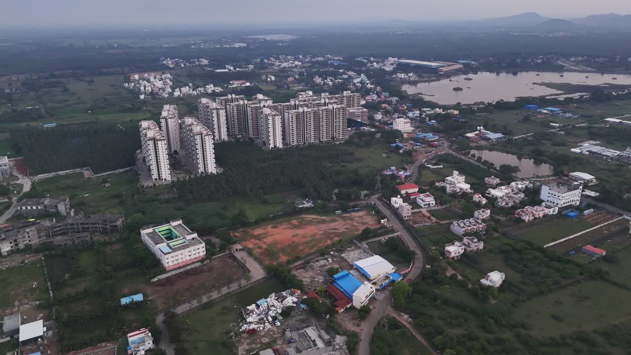 Un campo lungo di un paesaggio urbano che mette in evidenza l'espansione della città con nuove costruzioni. Edifici residenziali densi che coesistono con un paesaggio più rurale, case sparse e uno specchio d'acqua.