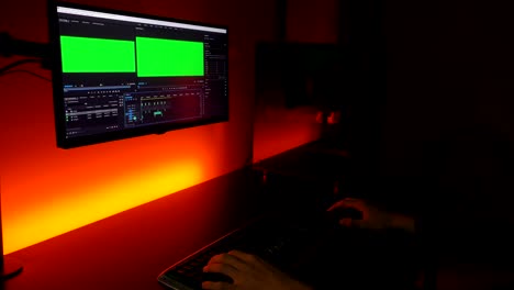 Pantalla-Verde:-Manos-Caucásicas-Escribiendo-En-El-Teclado-Trabajando-En-La-Edición-De-Video-En-La-Oficina-En-Casa-Oscura