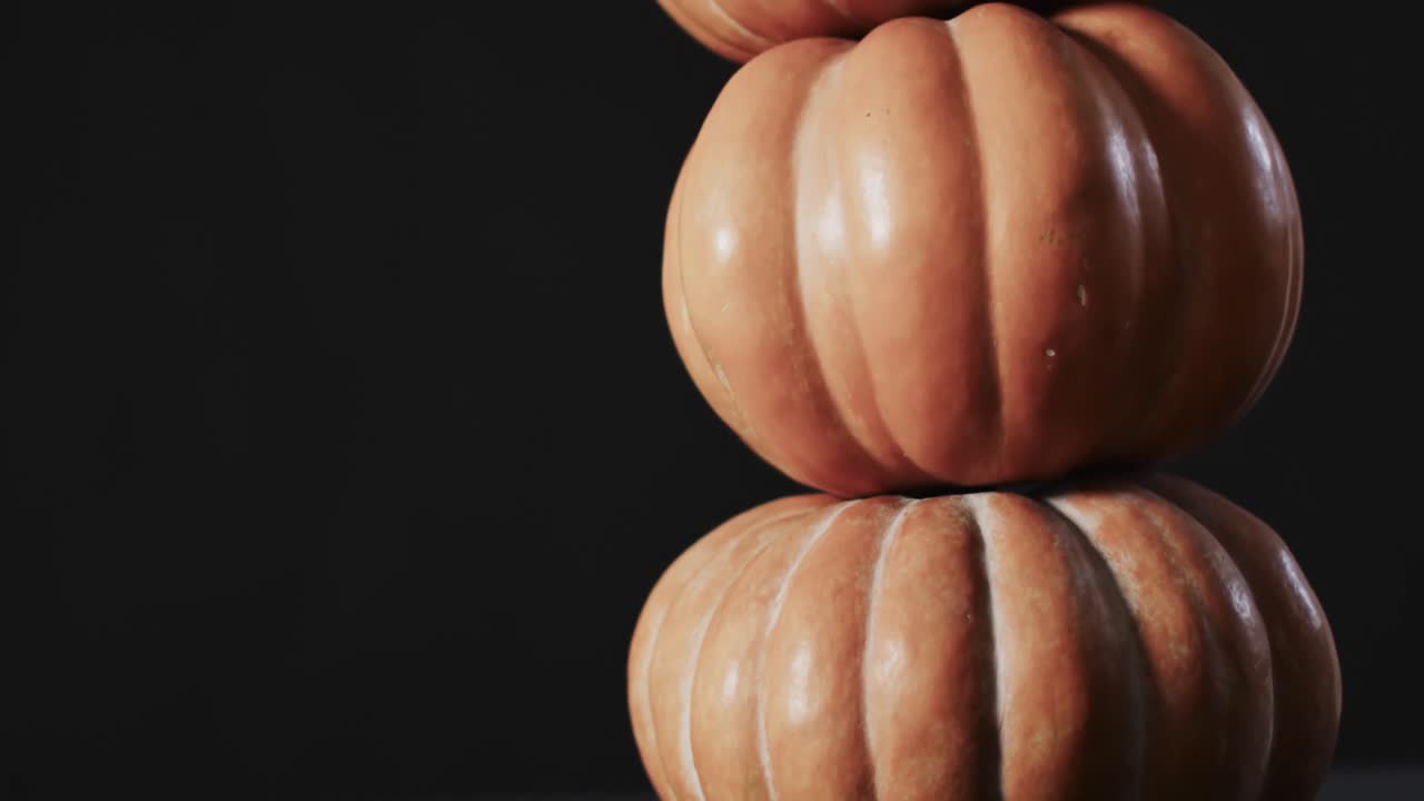 video de una pila de calabazas sobre un fondo negro