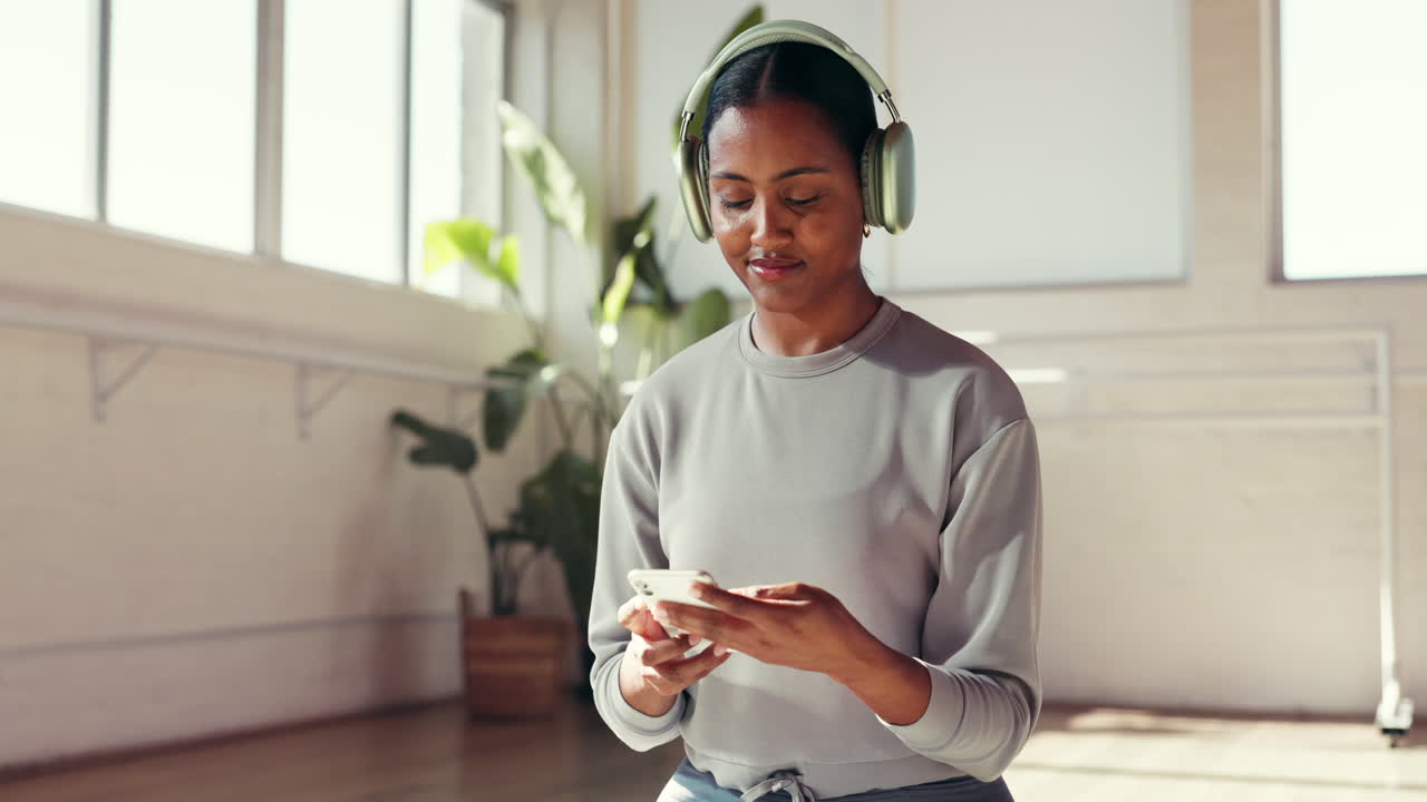 Donna che usa il cellulare con le cuffie in un ambiente chiuso