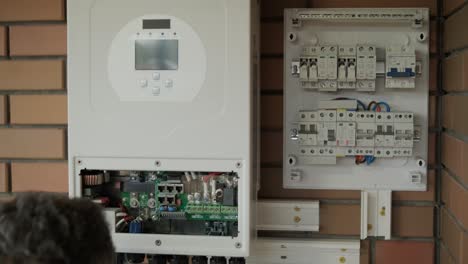 an electrician installing an inverter in a home. the image shows technical skill, modern tools, and attention to safety in electrical work