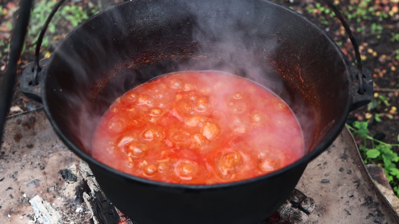Close up of goulash boiling in traditional cauldron, or bogrács over open fire