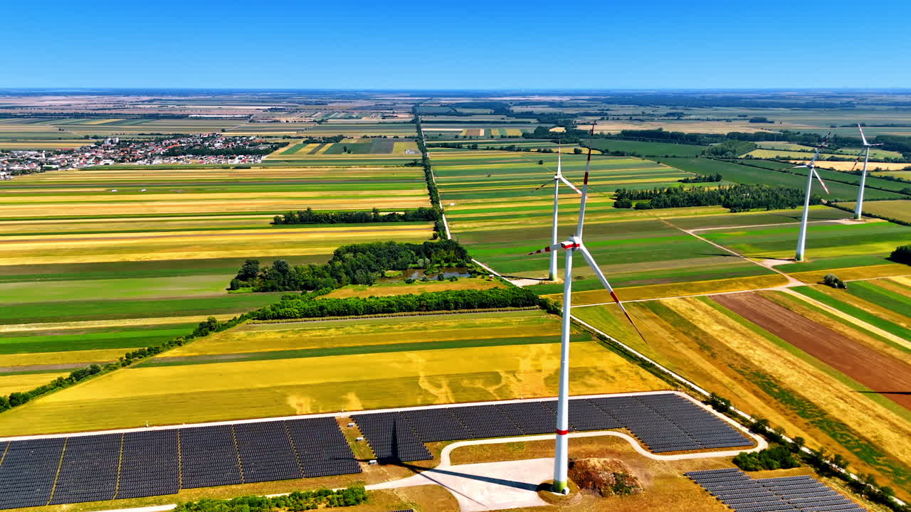 Beautiful bright fields with wind farms. Aerial perspective on the wind turbine near the solar panels