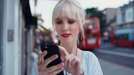 hermosa rubia usando teléfono inteligente en la ciudad