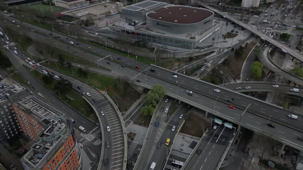 Complex multi-level highway interchange in Paris, with vehicles navigating curved ramps and overpasses, urban infrastructure and city mobility, Porte de la Chapelle, France