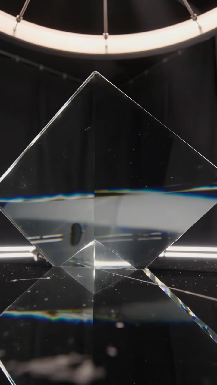 Video verticale: telecamera in movimento che fa ruotare un prisma in studio, luce ad anello che proietta un bordo arcobaleno