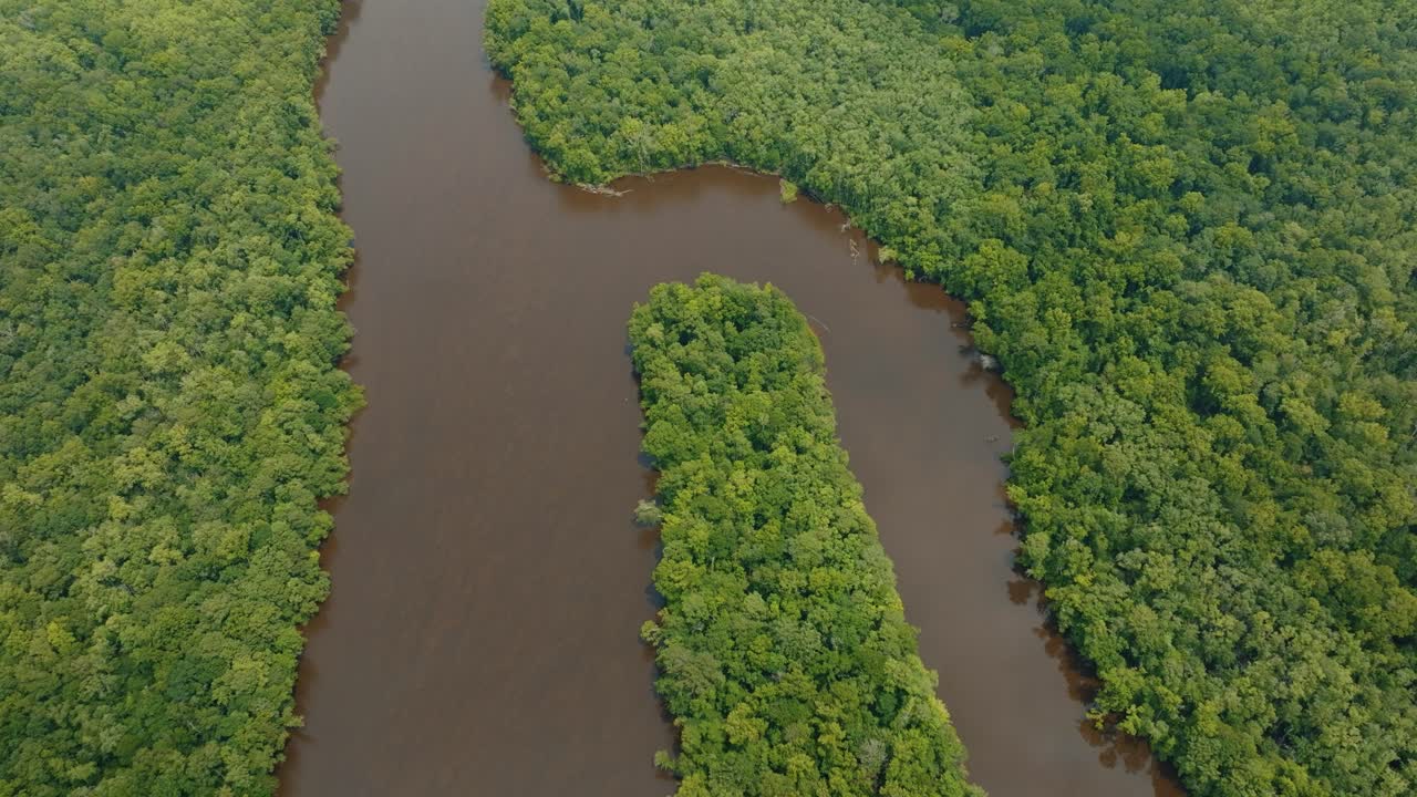 Looking down at a bend in the river through a green forest