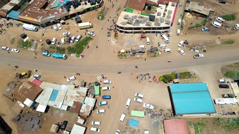 Aerial-view-of-cars-and-people-at-a-Open-Air-Market,-in-Africa---reverse,-drone-shot