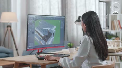 asian woman engineer design and zoom in 3d house with solar pannel while working on a desktop at home. cyber games house design and decoration