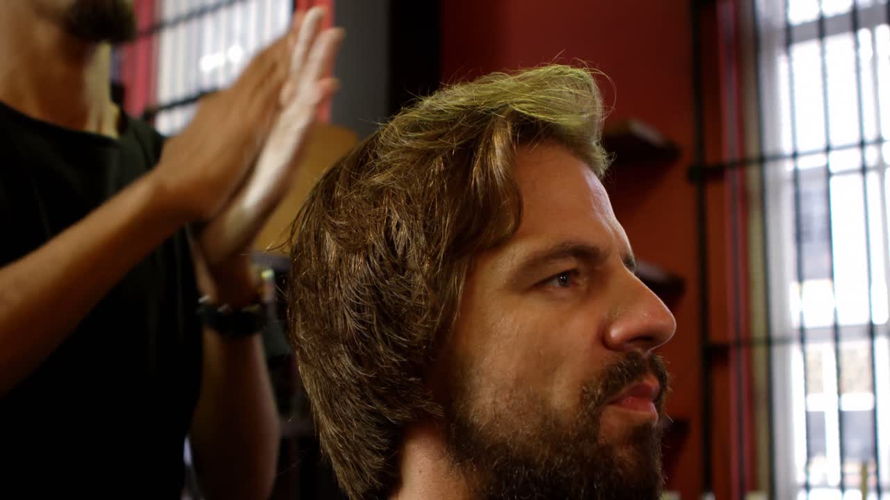 barbero aplicando cera para el cabello en el cabello del hombre 4k