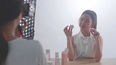 behind the scenes on photo shoot: beautiful asian model poses for a photographer, she takes photos with professional camera