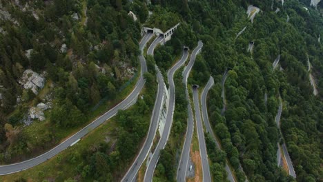 aerial view drone flight above the scenic mountain serpentine road plöckenpass in italy by the natural austrian alps in summer with green forest trees in nature and travel vacation cars on the street