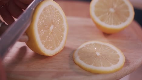 close interior static shot of slicing lemon on a wooden board