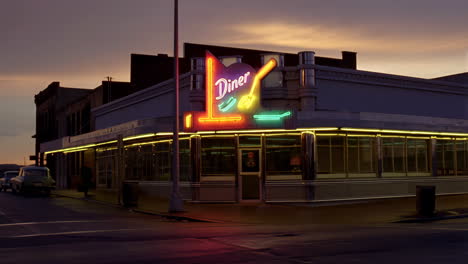 a classic diner with a bright neon sign at dusk