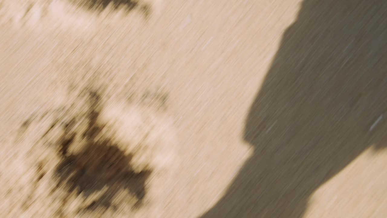 First Person View of Feet Walking on Sandy Ground