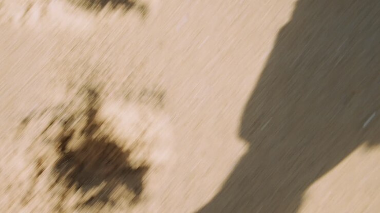 First Person View of Feet Walking on Sandy Ground