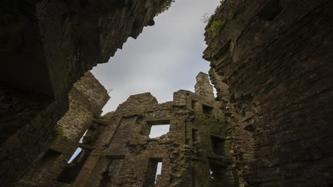 time lapse of a medieval castle ruin in rural countryside of ireland during a sunny cloudy day