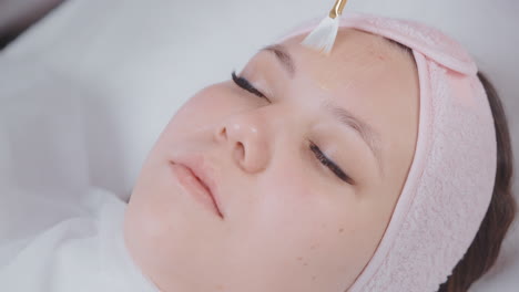 woman receiving facial mask application