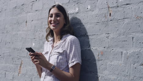 Mujer-Feliz-Enviando-Un-Mensaje-De-Texto-En-Su-Teléfono